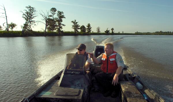  A U.S. Fish and Wildlife Service biologist and a refuge law enforcement officer patrol the Savannah National Wildlife Refuge in this 2008 photo, and in the photo at top. New rules proposed by the U.S. Secretary of the Interior would expand bird and big game hunting at the 29,000-acre refuge. PHOTOS BY STEPHEN MORTON