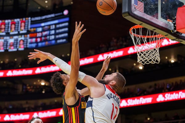 Atlanta Hawks forward Zaccharie Risacher, left, attempts a layup over Washington Wizards center Jonas Valanciunas, right, during the first half of an Emirates NBA Cup basketball game, Friday, Nov. 15, 2024, in Atlanta. (AP Photo/Jason Allen)