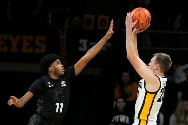 Iowa forward Payton Sandfort, right, looks to shoot over Michigan State guard Jase Richardson (11) during the first half of an NCAA college basketball game, Thursday, March 6, 2025, in Iowa City, Iowa. (AP Photo/Charlie Neibergall)