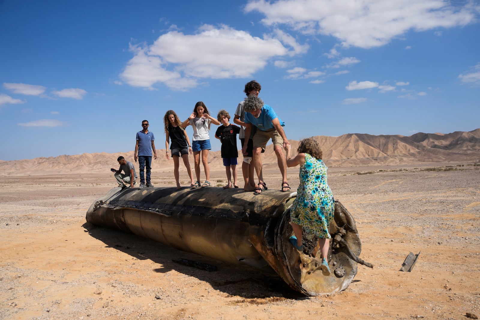 FILE - People climb on the debris of an Iranian missile intercepted by Israel, near Arad, southern Israel, Oct. 2, 2024. (AP Photo/Ohad Zwigenberg, File)