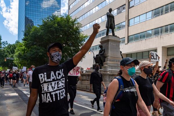 A group of protesters walks down Marietta Street on Saturday, June 13, 2020, past the statue of Henry Grady. JOHN AMIS FOR THE ATLANTA JOURNAL-CONSTITUTION.