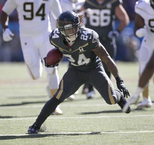 Atlanta Falcons running back Devonta Freeman (24) of Team Irvin runs through the Team Rice defense during the first quarter of the NFL Pro Bowl football game, Sunday, Jan. 31, 2016, in Honolulu. (AP Photo/Marco Garcia)