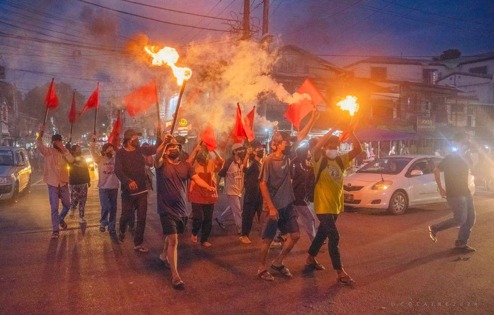 Pro-democracy protesters hold torches and flags during a flash mob rally to protest against Myanmar's military-government in Yangon, Myanmar on Sept.19, 2024. (Anti-Junta Alliance Yangon via AP)