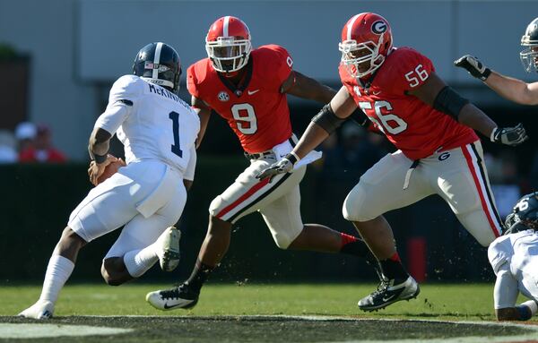 Georgia Southern quarterback Jerick McKinnon keeps on the option only to find Georgia defenders Alec Ogletree, left, and Garrison Smith waiting for him in 2012.  BRANT SANDERLIN / BSANDERLIN@AJC.COM