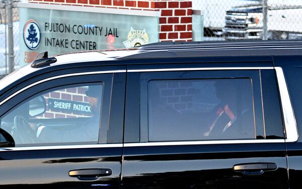 Former President Donald Trump enters the Fulton County Jail in August to surrender on charges involving the county's election interference investigation. (Hyosub Shin / Hyosub.Shin@ajc.com)