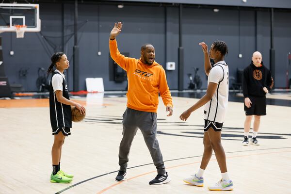 Coach Corey Frazier (center) gives directions to Jayden Wilkins (right) during a training session at Overtime Elite Arena on Monday, Nov. 6, 2023. (Miguel Martinez /miguel.martinezjimenez@ajc.com)