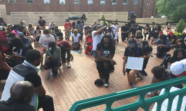 At the King Center, march organizer Asante Hill leads the group for about eight minutes of silence.