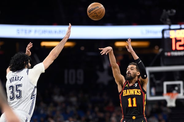 Atlanta Hawks guard Trae Young (11) shoots a 3-point basket as Orlando Magic center Goga Bitadze (35) defends during the first half of an NBA basketball game, Monday, Feb. 10, 2025, in Orlando, Fla. (AP Photo/Phelan M. Ebenhack)