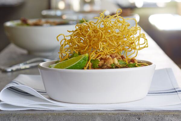 Bowl of Brussels with hot brussels sprouts, fresh basil. cilantro, crunchy rice noodles, carrots, savory teriyaki and crushed macadamia nuts. Photo Credit: Lauren Rubinstein