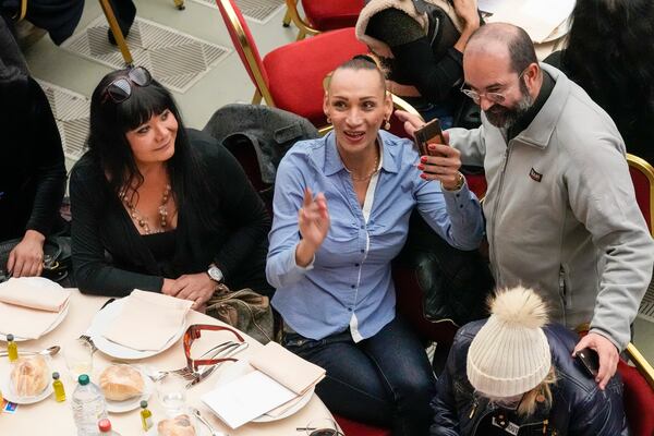 FILE- Priest Andrea Conocchia, right, with members of a group of transgender women he accompanied at a lunch for the poor with Pope Francis, in the Paul VI Hall at the Vatican, Sunday, Nov. 19, 2023. (AP Photo/Andrew Medichini, File)