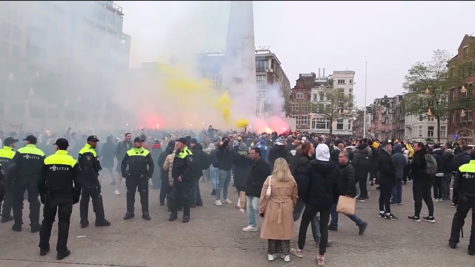 In this image taken from video, police stand guard as Maccabi Tel Aviv supporters light flares at the Dam square, in Amsterdam, the Netherlands, Thursday, Nov. 7, 2024. (AP Photo InterVision)