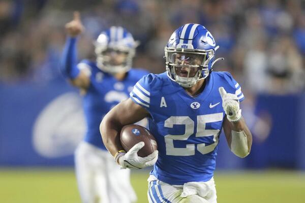 BYU running back Tyler Allgeier (25) runs for a touchdown as BYU quarterback Jaren Hall (3) celebrates during the first half of an NCAA college football game against Virginia Saturday, Oct. 30, 2021, in Provo, Utah. (AP Photo/George Frey)