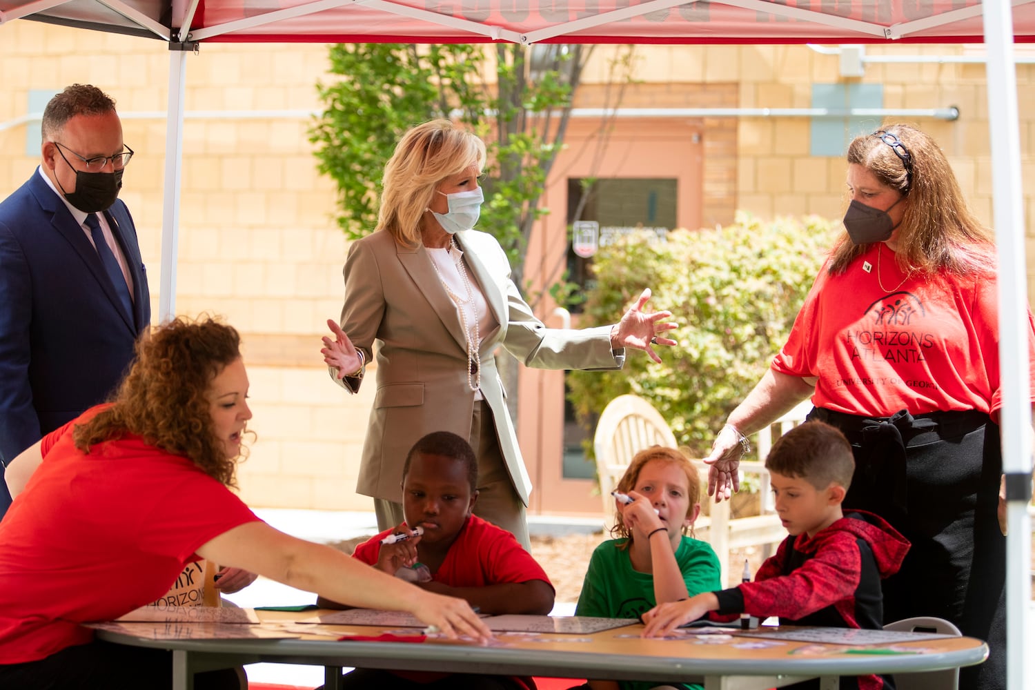 First Lady Jill Biden and Education Secretary Miguel Cardona speak with Susan Cardin, the Horizons Atlanta program director, as first-grade students show an example of a literacy lesson while the two visit a Horizons Atlanta summer learning program at the University of Georgia in Athens, Georgia on Thursday, July 21, 2022. The program serves students from Barnett Shoals Elementary School. (Chris Day/Christopher.Day@ajc.com)