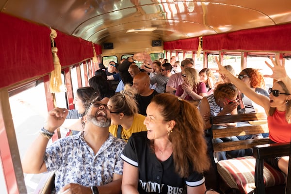 Riders on the Funny Bus react after getting mooned by a person along Memorial Drive on Saturday, Nov. 2, 2024. (Ben Gray for the AJC)