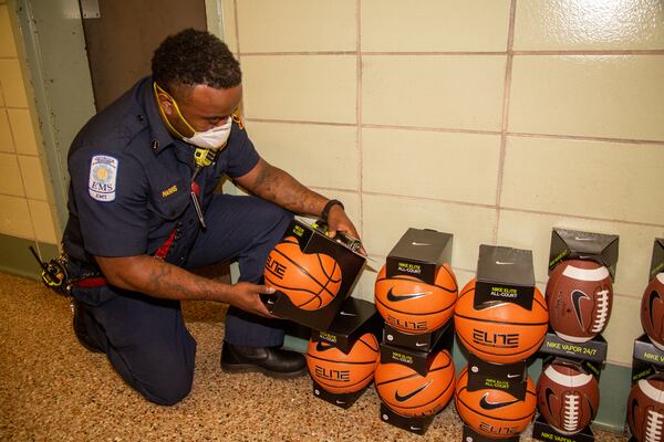 Lt Douglas Harris looks at some sports equipment in a room that is normally filled with kids toys & gifts this time of year for the community-wide Christmas Party that Atlanta Fire Department's Station 16 has hosted for 50 years in Vine City. The party had to be cancelled this year due to COVID-19. The station is also where the city's first African-American firefighters were employed. PHIL SKINNER FOR THE ATLANTA JOURNAL-CONSTITUTION.