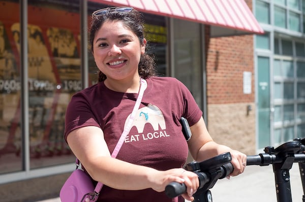 Cristina Sanchez prepares to board a shareable e-scooter near Centennial Olympic Park. (Alyssa Pointer/alyssa.pointer@ajc.com)