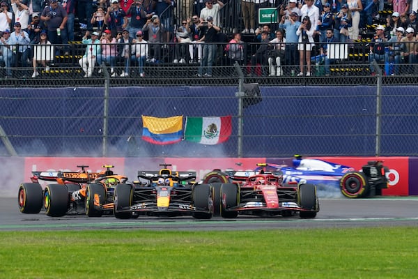 RB driver Yuki Tsunoda of Japan, back, crashes during the Formula One Mexico Grand Prix auto race at the Hermanos Rodriguez racetrack in Mexico City, Sunday, Oct. 27, 2024. (AP Photo/Moises Castillo)