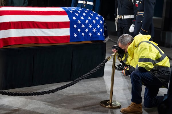 A mourner kneels at the casket of former President Jimmy Carter at the Carter Presidential Center in Atlanta on Monday. 