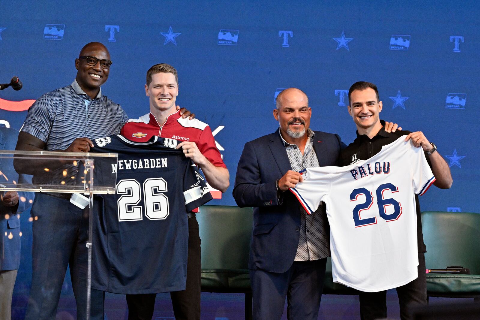 From left, former NFL player DeMarcus Ware, IndyCar driver Josef Newgarden, former baseball player Pudge Rodriguez and IndyCar driver Alex Palou pose for a group photo during a news conference announcing the IndyCar Grand Prix of Arlington to be held in 2026 in Arlington, Texas, Tuesday, Oct. 8, 2024. (AP Photo/Jerome Miron)