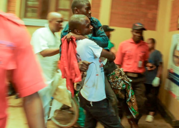 In this video frame grab, people assist victims after two explosions hit a meeting of M23 rebel group leaders and residents in Bukavu, eastern Congo, Thursday, Feb. 27, 2025. (AP Photo/Janvier Barhahiga)