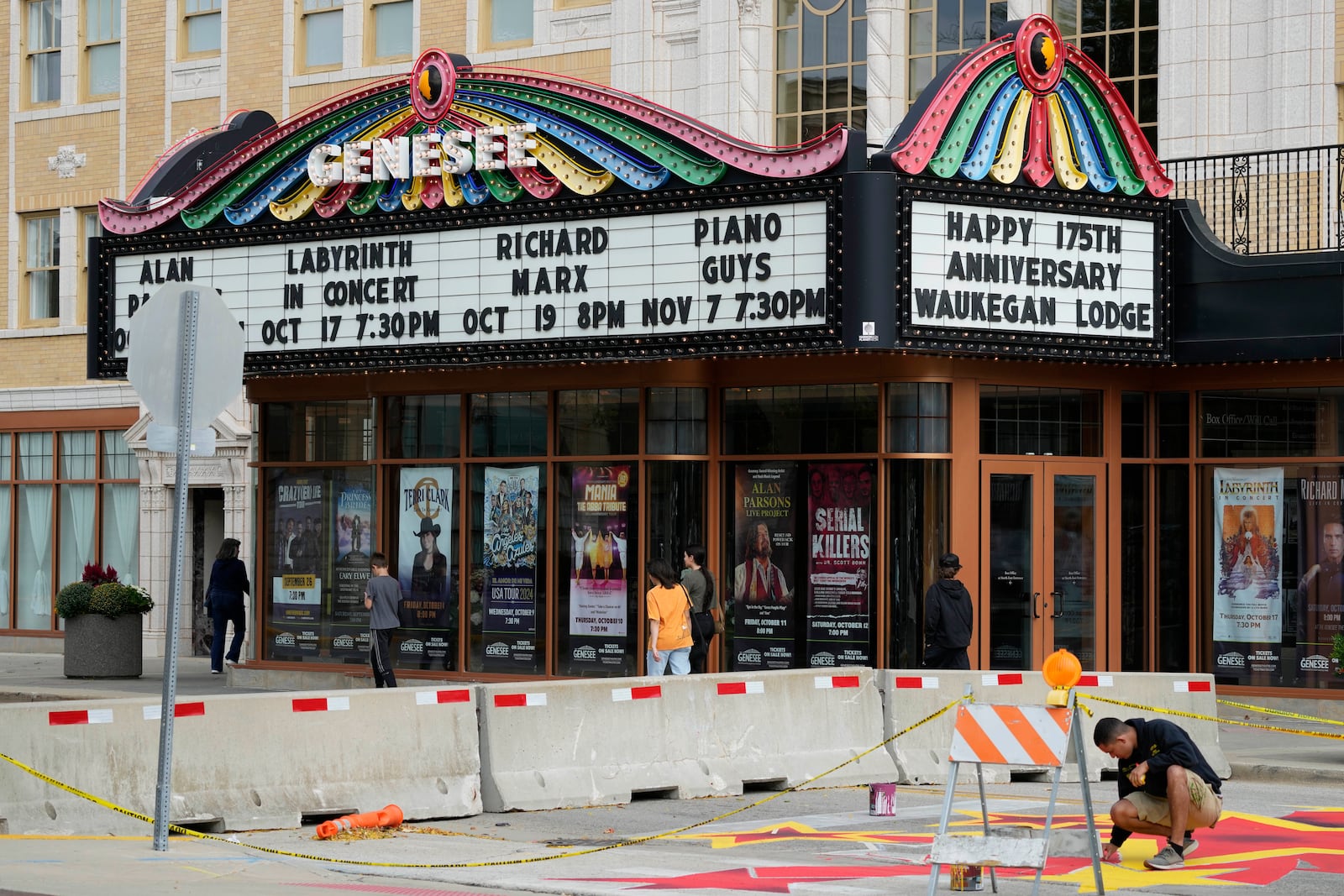 People walk past a theatre in Waukegan, Ill., Saturday, Sept. 28, 2024. (AP Photo/Nam Y. Huh)