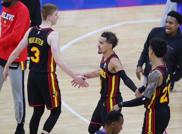 Hawks guards Kevin Huerter (left), Trae Young (center), and forward John Collins celebrate the 103-96 victory over the Philadelphia 76ers in Game 7 of the Eastern Conference semifinals Sunday, June 20, 2021, in Philadelphia. (Curtis Compton / Curtis.Compton@ajc.com)