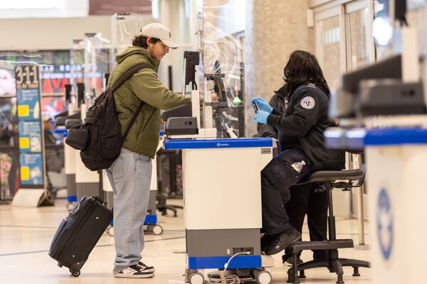 A traveler passes through one of the reopened security lanes in the domestic terminal at Hartsfield-Jackson in Atlanta on Thursday, December 14, 2023. (Arvin Temkar / arvin.temkar@ajc.com)