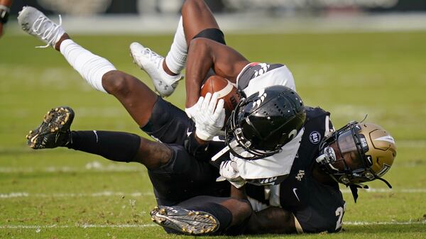 Central Florida defensive back Richie Grant (right) tackles Cincinnati wide receiver Jayshon Jackson after a reception  Saturday, Nov. 21, 2020, in Orlando, Fla. (John Raoux/AP)