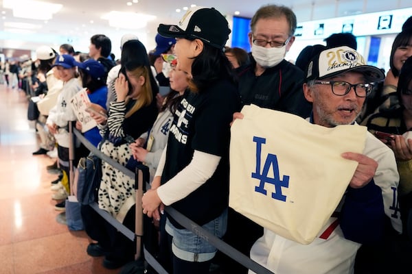 Fans of Los Angeles Dodgers wait for the team arrival at Tokyo International Airport Thursday, March 13, 2025, in Tokyo, as Los Angeles Dodgers is scheduled to play their MLB opening games against Chicago Cubs in Tokyo on March 18-19. (AP Photo/Hiro Komae)