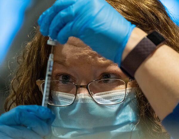 Registered Nurse Connie Harwood fills a syringe with COVID-19 vaccine during an event earlier this month for Fulton County school employees and their spouses who are 65 and older. The emergence of variant COVID-19 strains in the U.S. has intensified the race to vaccinate as many people as possible, as quickly as possible. (Ben Gray for The Atlanta Journal-Constitution)