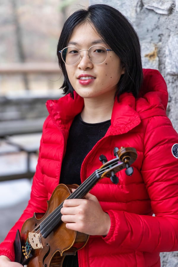 Jean Yu holds her violin at Jones Bridge Park in Peachtree Corners. PHIL SKINNER FOR THE ATLANTA JOURNAL-CONSTITUTION