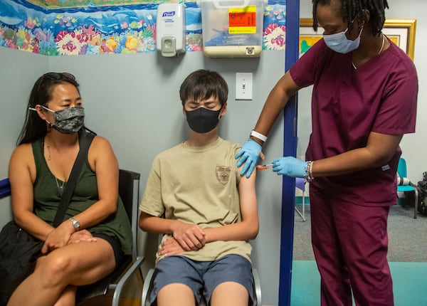 Samuel Hershner (C)receives his Covid 19 shot by RMA Phoena Mack (R) while sitting next to his mother Diane Hershner in  Decatur Monday, June 14, 2021.  STEVE SCHAEFER FOR THE ATLANTA JOURNAL-CONSTITUTION