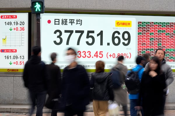 People walk in front of an electronic stock board showing Japan's Nikkei index at a securities firm Thursday, March 6, 2025, in Tokyo. (AP Photo/Eugene Hoshiko)