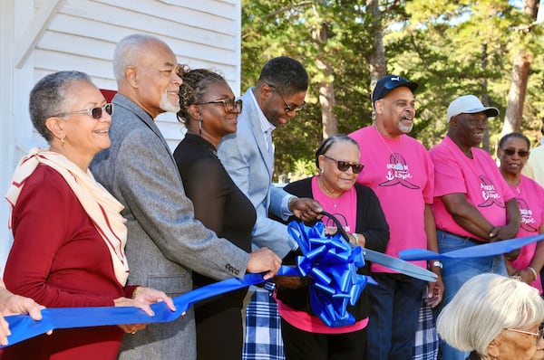 Members of the Friends of Cherry Grove School cut the ribbon for the grand opening of the refurbished school in October 2022. They  are (from left) Kathryn Anderson, secretary; Edward M. Anderson, vice chair; Lorraine Hanson; Barrett Hanson, chair; the Rev. Kathy Butler, pastor of Cherry Grove Baptist Church; Deacon Andre Butler and Deacon Jimmy Harris and his wife.  Courtesy of Georgia Historic Trust