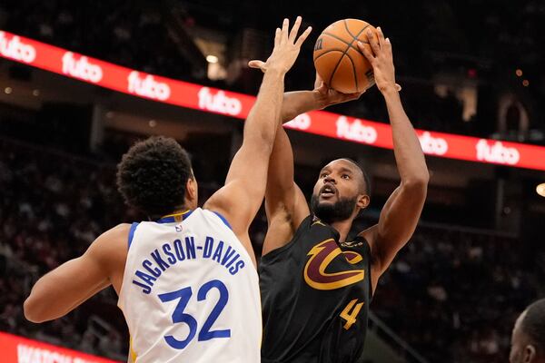 Cleveland Cavaliers forward Evan Mobley (4) shoots as Golden State Warriors forward Trayce Jackson-Davis (32) defends in the second half of an NBA basketball game, Friday, Nov. 8, 2024, in Cleveland. (AP Photo/Sue Ogrocki)