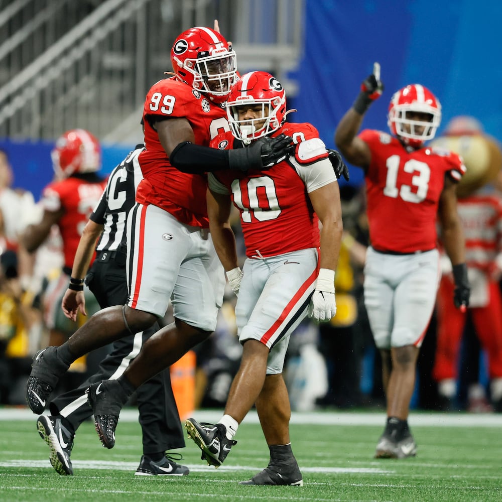 Georgia Bulldogs linebacker Jamon Dumas-Johnson (10) celebrates his sack of Ohio State Buckeyes quarterback C.J. Stroud (7) with  defensive lineman Bear Alexander (99) during the fourth quarter of the College Football Playoff Semifinal between the Georgia Bulldogs and the Ohio State Buckeyes at the Chick-fil-A Peach Bowl In Atlanta on Saturday, Dec. 31, 2022.  Georgia won, 42-41. (Jason Getz / Jason.Getz@ajc.com)