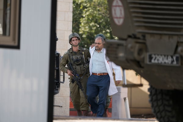 Israeli troops detain the director of the Turkish hospital doctor Mohammad Samara for interrogation before releasing him, while searching for the bodies of militants in a Palestinian hospital in the West Bank city of Tubas, Tuesday Dec. 3, 2024 (AP Photo/Majdi Muhammad).