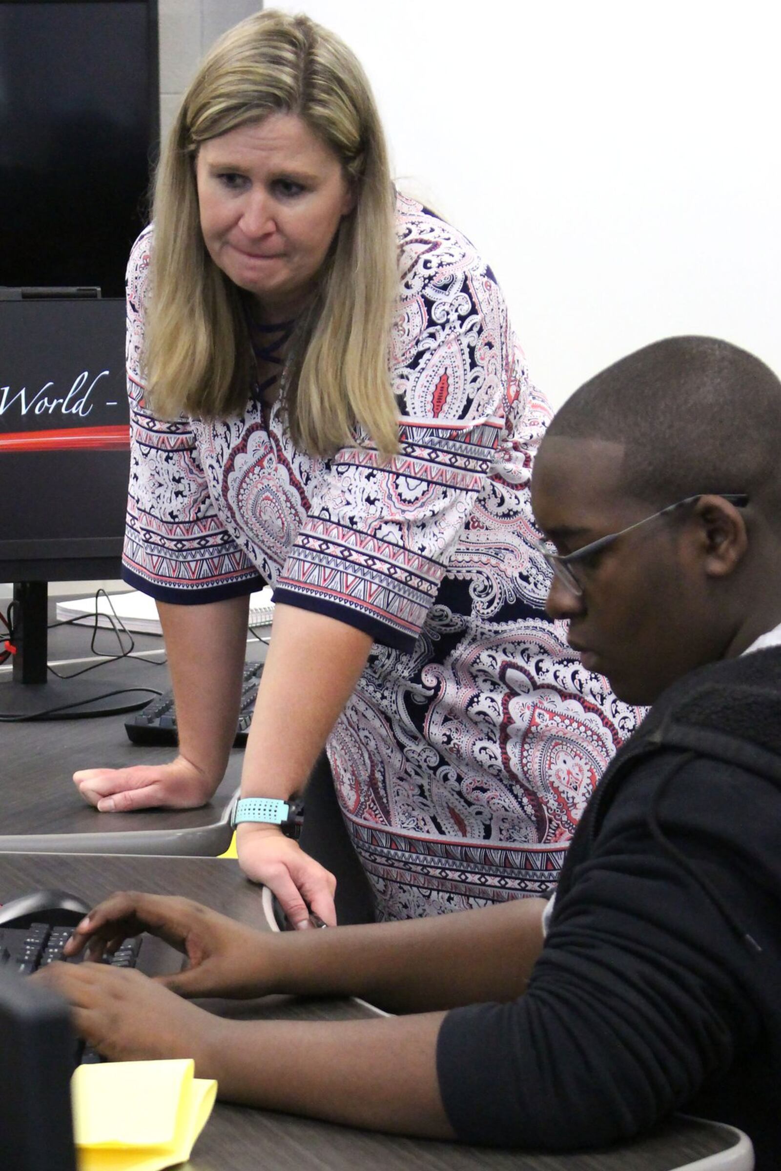 Beckie Mae, a teacher at Paul Duke STEM High School, helps a student login to their computers in an AP computer science class during their first day at school on Monday, August 6. Jenna Eason / Jenna.Eason@coxinc.com