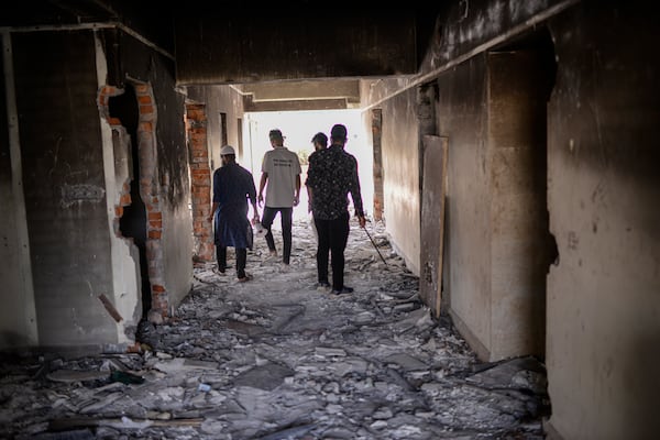 Protesters walk through ransacked Awami League party office in Dhaka, Bangladesh, Sunday, Nov. 10, 2024. (AP Photo/Mahmud Hossain Opu)