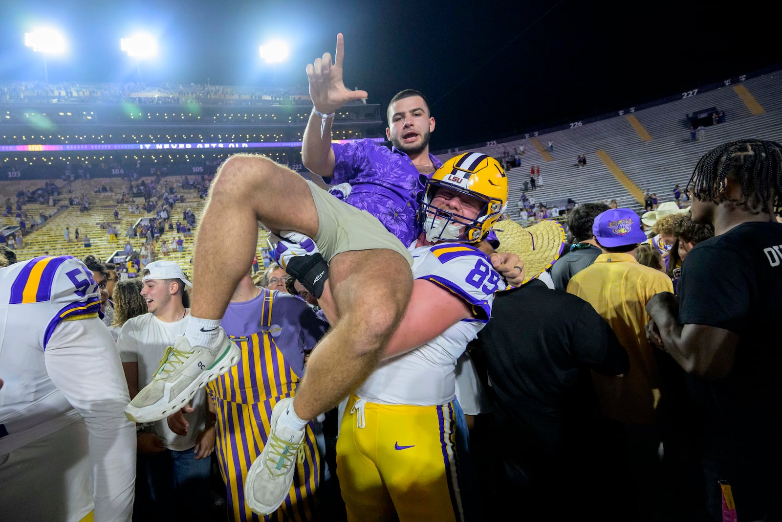 LSU offensive lineman Bo Bordelon (89) celebrates with LSU fans after they rushed the field after the team's overtime victory over Mississippi during an NCAA college football game in Baton Rouge, La., Saturday, Oct. 12, 2024. (AP Photo/Matthew Hinton)