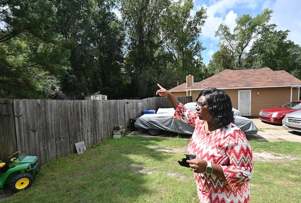 Deandra Bradley shows the proximity to Carver Park from her backyard in Columbus. Bradley says she hears gunshots from the park and says she's had to teach her children to move away from windows and drop to the floor when they hear firearms.(Hyosub Shin / Hyosub.Shin@ajc.com)