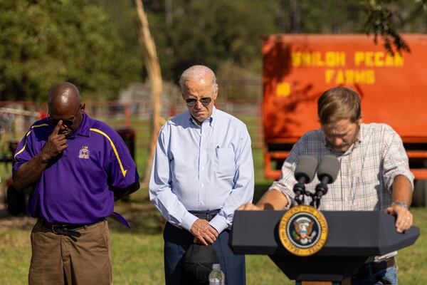 President Joe Biden bows his head as pecan farmer Buck Paulk says a prayer at his farm in Ray City on Thursday, October 3, 2024. The president was surveying damage from Hurricane Helene. (Arvin Temkar / AJC)
