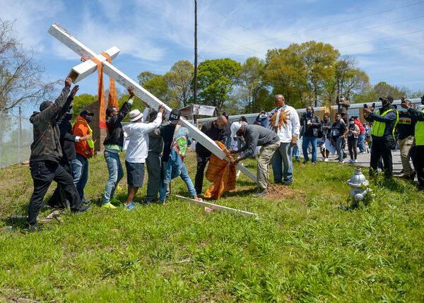 Participants raise a cross that bears the names of victims of the Chattahoochee Brick Company’s convict lease system during an event to commemorate the lives lost during the period the company was in business. The event included a procession, prayers, libations, community testimonials, and site consecration Saturday, April 3, 2021, in Atlanta. (Photo: Daniel Varnado for The Atlanta Journal-Constitution)