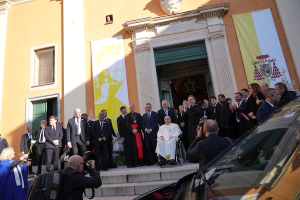 Pope Francis greets faithful as he arrives outside the Cathedral of Our Lady of the Assumption of Ajaccio on the occasion of his one-day visit in the French island of Corsica, Sunday, Dec. 15, 2024. (AP Photo/Alessandra Tarantino)