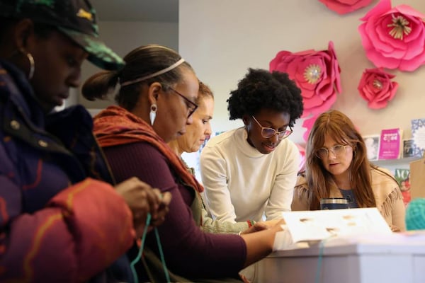 Judah David Creations owner Darice Oppong (second from right) helps team members from Resilience Georgia practice their first stitches in her beginner crochet class on Wednesday, Dec. 11, 2024, at The Web in Macon, Georgia. (Photo Courtesy of Katie Tucker/The Telegraph)