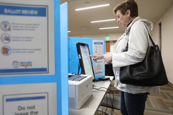 Andrea Settles practices completing a ballot on one of Fulton County’s new voting machines during a mock election in February at the Sandy Springs Library. She mentioned that the voting process was easy, but for election day, they will need to have a lot of signs instructing the voters on the new process. Miguel Martinez for The Atlanta Journal-Constitution