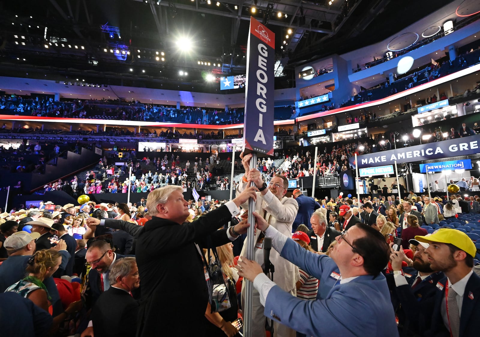 Brad Hughes, from left, Jason Thompson and Josh McKoon, the chair of the Georgia Republican Party, pick up the state's delegate marker during the final day of 2024 Republican National Convention in Milwaukee. Republicans came out of the convention feeling good about their chances of regaining the presidency, but McKoon has warned them not to get complacent. (Hyosub Shin / AJC)