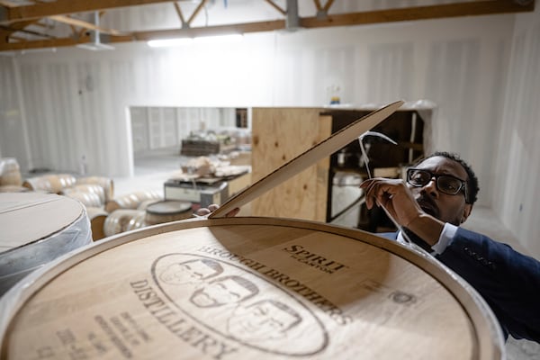 Victor Yarbrough, CEO of Brough Brothers Distillery, removes the cover from an empty barrel of bourbon in the under construction facility in Louisville, Ky., Saturday, March 8, 2025. (AP Photo/Jon Cherry)