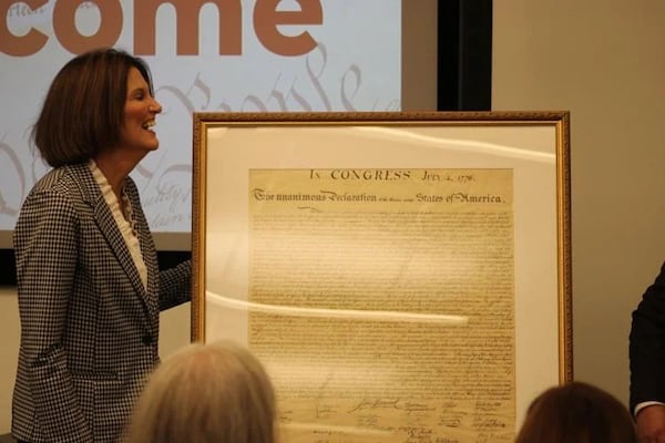 Kennesaw State University President Kathy Schwaig helps reveal the university’s newly-restored copy of the Declaration of Independence from 1843. (Photo Courtesy of Jack Lindner)