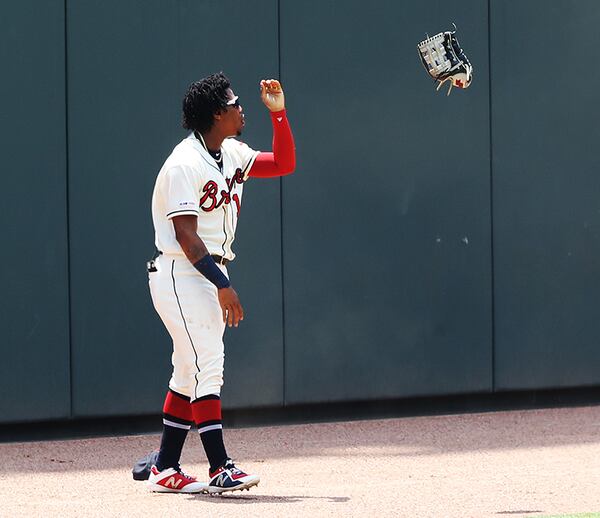 Braves outfielder Ronald Acuna tosses his glove after failing to come down with a home run ball off the bat of the Dodgers' Cody Bellinger during the first inning Sunday, Aug. 18, 2019, at SunTrust Park in Atlanta.